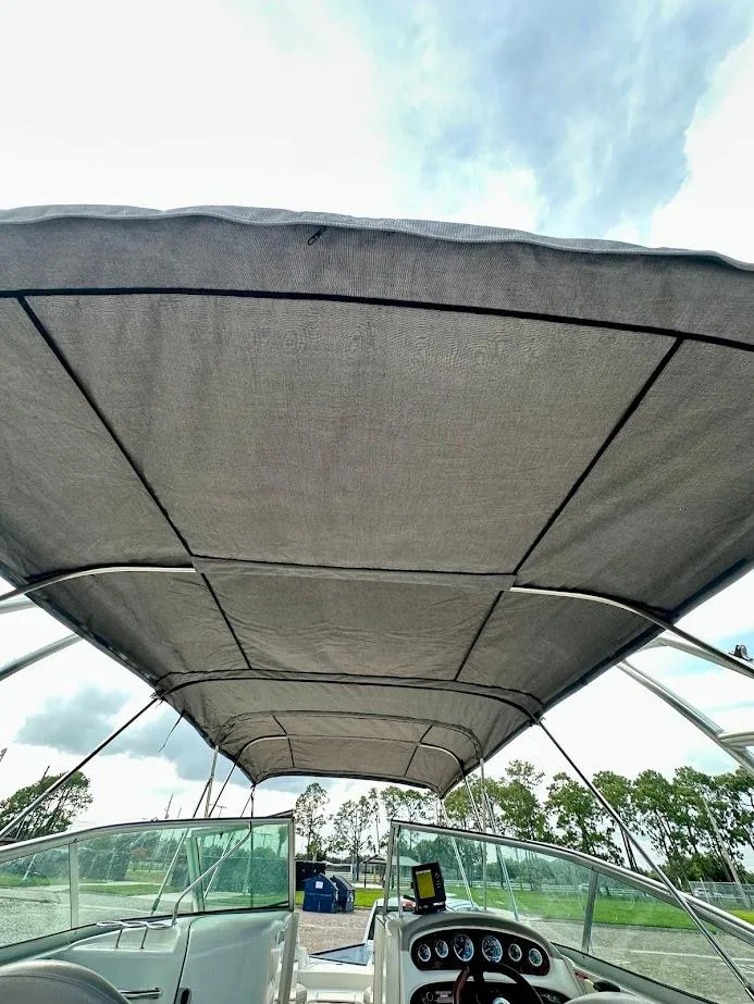 Slide: The Image of 2004 Sea Ray SUNDECK 270 boat interior with canopy, showcasing helm and windshield. - 42