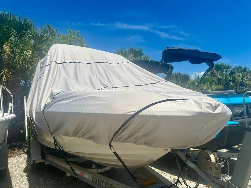 Slide: The Image of Covered 2004 Sea Ray SUNDECK 270 boat on trailer, surrounded by trees under a clear blue sky. - 45