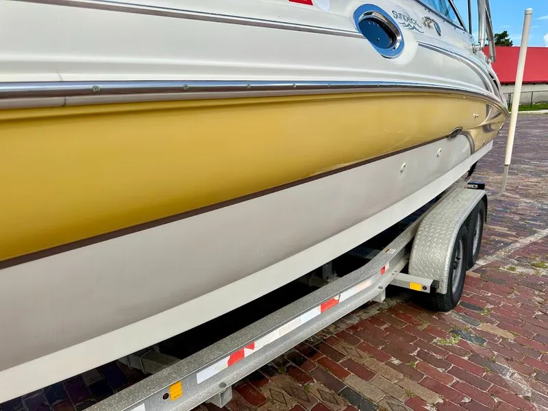Slide: The Image of 2004 Sea Ray SUNDECK 270 boat on trailer, yellow and white exterior. - 8
