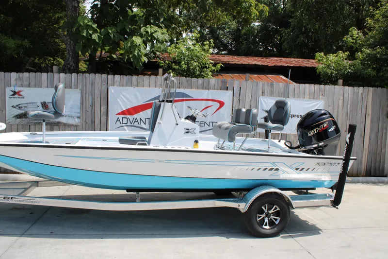 The Image of 2025 Xpress H20B boat on trailer, displayed outdoors with promotional banners. - 1