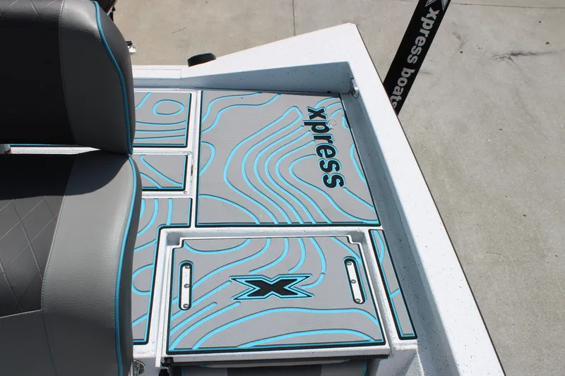 Slide: The Image of 2025 Xpress H20B boat interior with custom blue and gray deck design. - 11