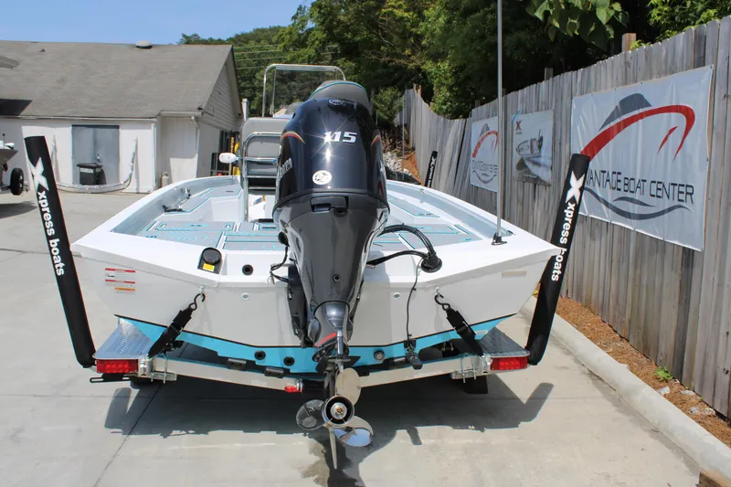 Slide: The Image of 2025 Xpress H20B boat with motor, parked at a boat center. - 3