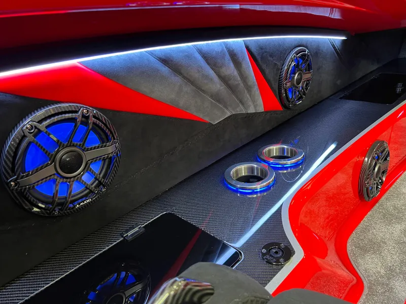 Slide: The Image of 2023 Daves Custom Boats M37R interior with sleek red design, illuminated speakers, and cup holders. - 27
