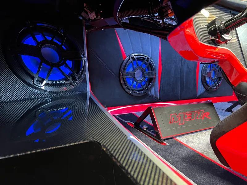 Slide: The Image of 2023 Daves Custom Boats M37R interior with blue-lit speakers and sleek carbon fiber accents. - 28