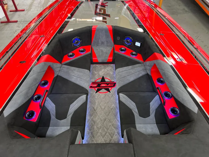 Slide: The Image of 2023 Daves Custom Boats M37R interior with red and gray seating, modern design, and audio system. - 31
