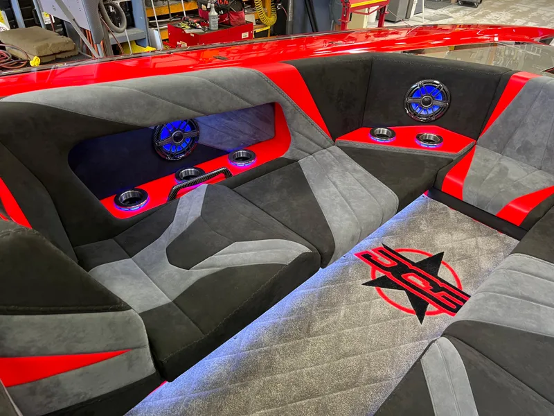 Slide: The Image of 2023 Daves Custom Boats M37R interior with red and gray seating, speakers, and LED lighting. - 33