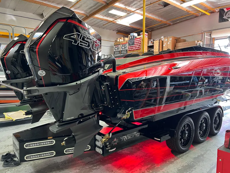 Slide: The Image of 2023 Daves Custom Boats M37R with dual engines, red and black design, in a workshop setting. - 38