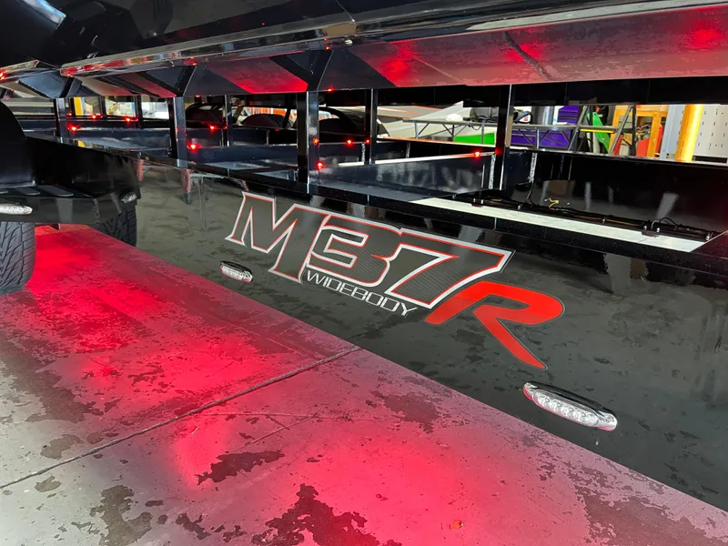 Slide: The Image of 2023 Daves Custom Boats M37R with red underglow lighting on a wet surface. - 39