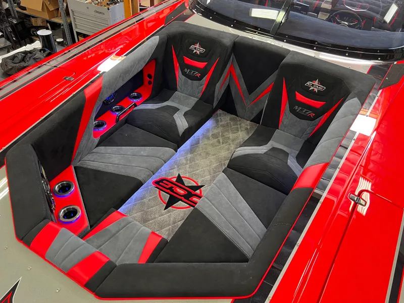 Slide: The Image of 2023 Daves Custom Boats M37R interior with red and black seating, cup holders, and LED lighting. - 5