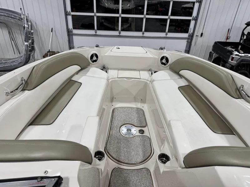 Slide: The Image of 2006 Sea Ray 260 Sundeck interior with beige seating and carpeted floor in a garage. - 10