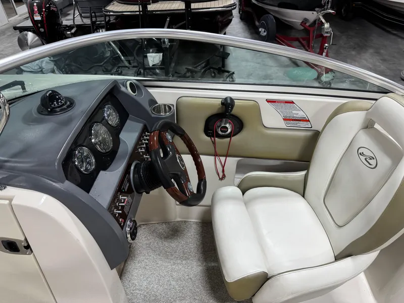 Slide: The Image of 2006 Sea Ray 260 Sundeck cockpit with steering wheel and gauges, featuring white seating. - 9