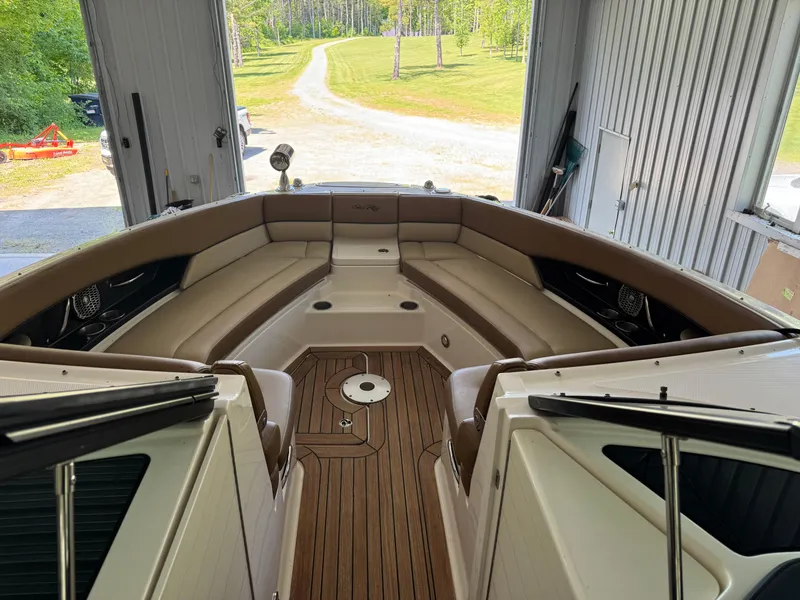 Slide: The Image of 2015 Sea Ray 350 SLX boat interior with brown seating and wooden flooring in a garage. - 12