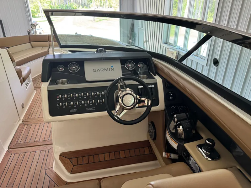 Slide: The Image of 2015 Sea Ray 350 SLX boat interior with Garmin navigation system and luxurious seating. - 13