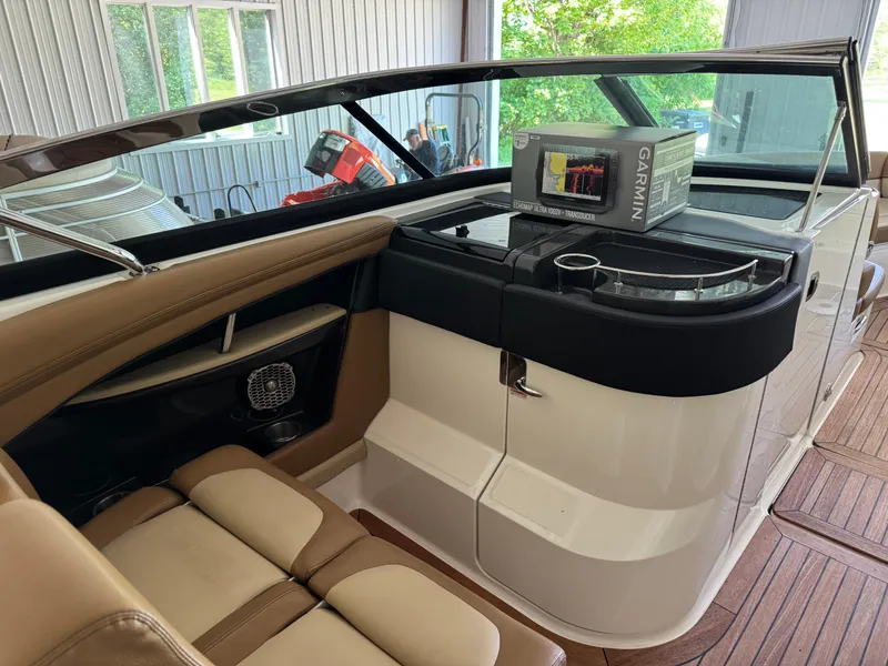 Slide: The Image of 2015 Sea Ray 350 SLX interior with Garmin electronics, brown seating, and wood flooring. - 14