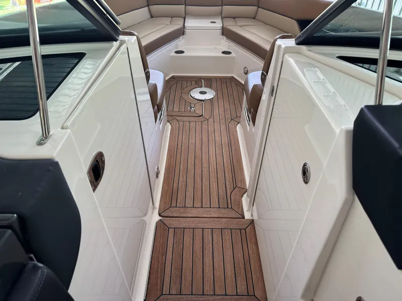 Slide: The Image of 2015 Sea Ray 350 SLX boat interior with teak flooring and cushioned seating. - 15
