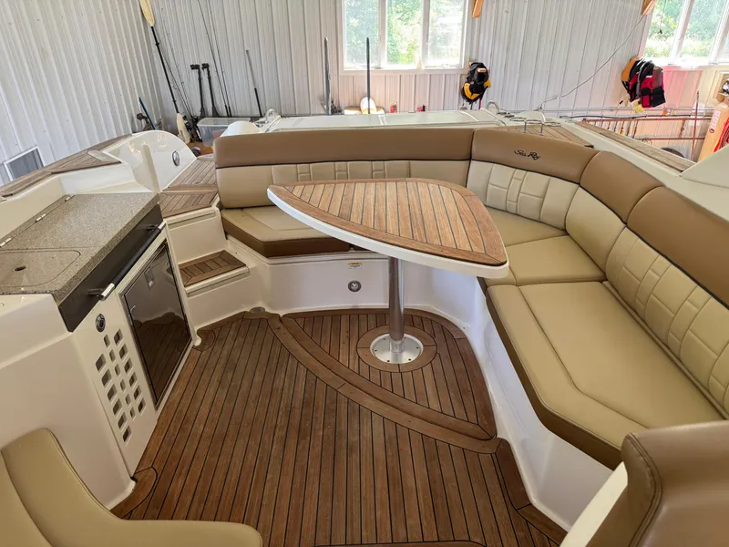 Slide: The Image of 2015 Sea Ray 350 SLX boat interior with tan seating and wooden table. - 22