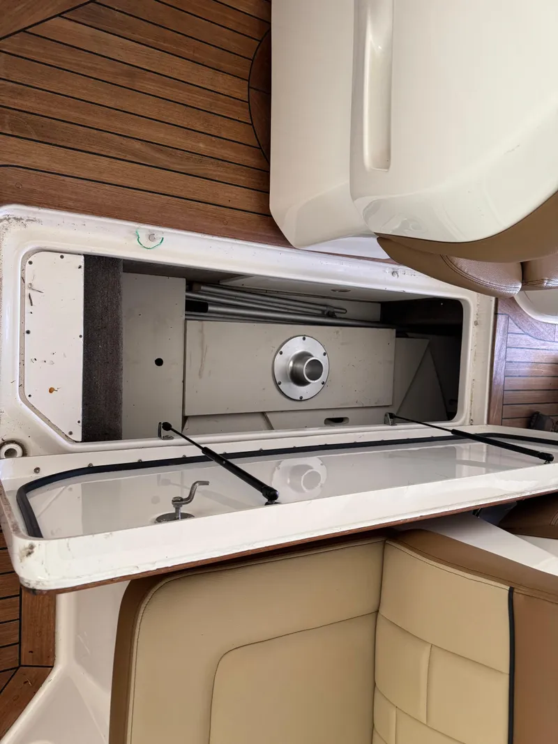 Slide: The Image of 2015 Sea Ray 350 SLX storage compartment with teak flooring and beige seating. - 9