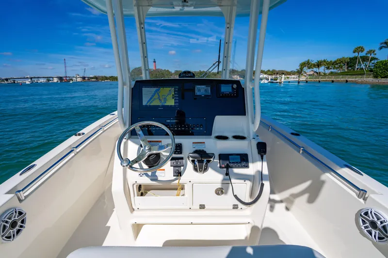 Slide: The Image of 2022 Cobia 240 CC boat dashboard with navigation system on a sunny day. - 11