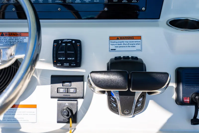 Slide: The Image of Control panel of 2022 Cobia 240 CC boat with steering wheel and warning labels. - 13