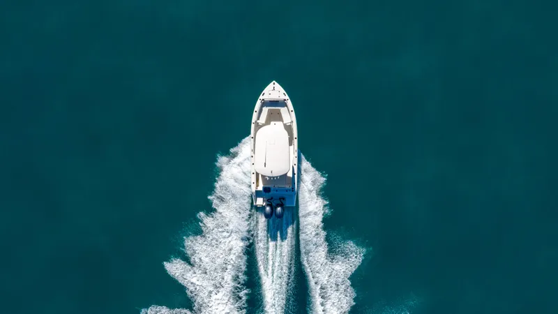 Slide: The Image of Aerial view of 2022 Cobia 240 CC boat cruising on clear blue water. - 31