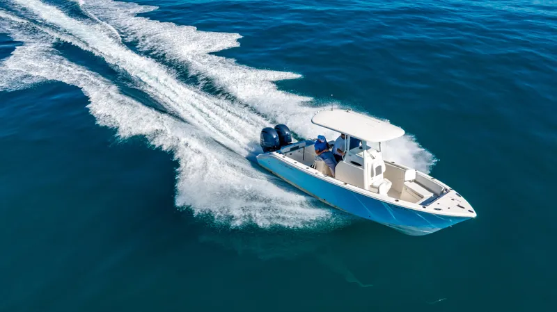 Slide: The Image of 2022 Cobia 240 CC boat cruising on open blue water. - 33