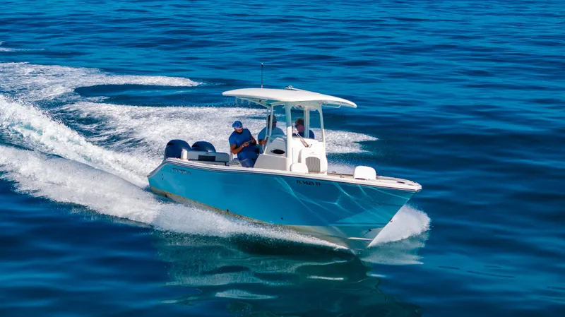 Slide: The Image of 2022 Cobia 240 CC boat cruising on open blue water. - 34