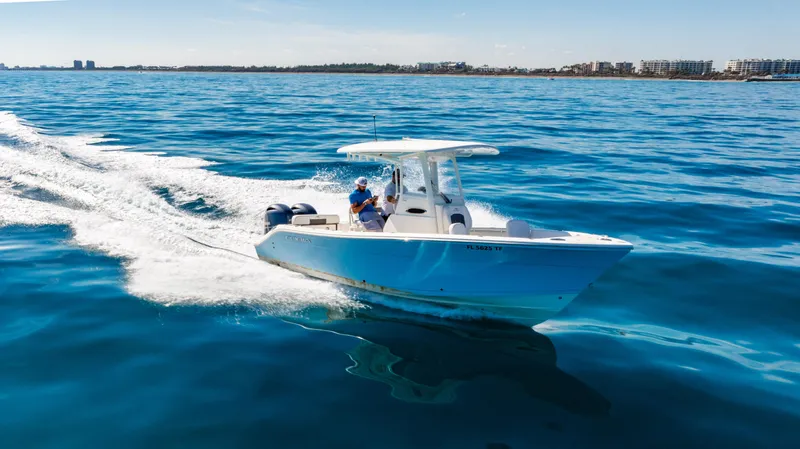 Slide: The Image of 2022 Cobia 240 CC boat cruising on open water, clear blue sky. - 36