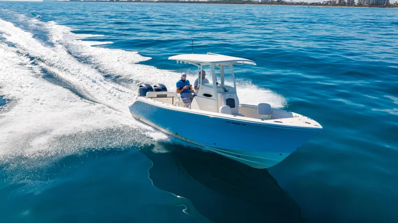 Slide: The Image of 2022 Cobia 240 CC boat cruising on open blue water. - 38