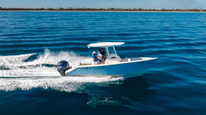 Slide: The Image of 2022 Cobia 240 CC boat cruising on open blue water. - 40