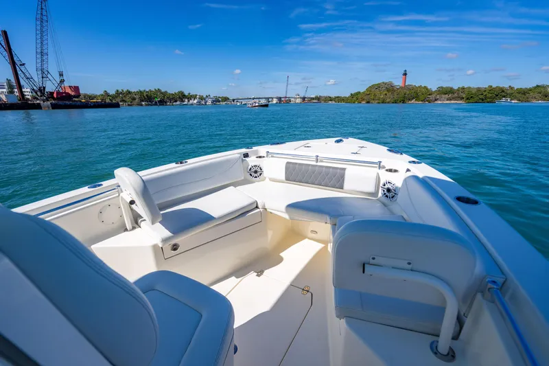 Slide: The Image of 2022 Cobia 240 CC boat on water, featuring spacious seating and scenic coastal view. - 7