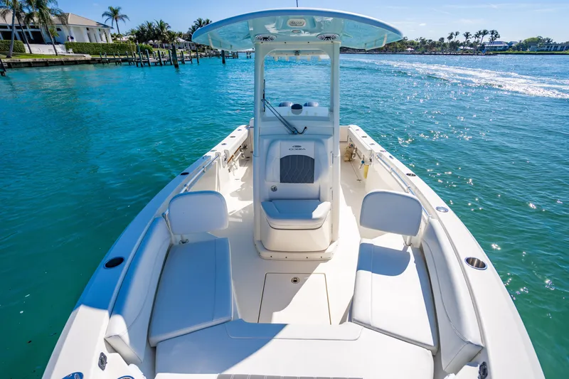 Slide: The Image of 2022 Cobia 240 CC boat on clear blue water, featuring spacious seating and sleek design. - 9