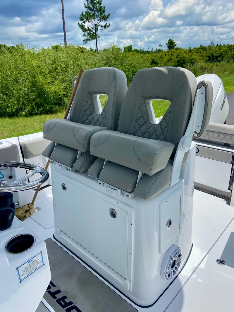Slide: The Image of 2025 Sportsman Open 262 Center Console boat seats with lush greenery in the background. - 11