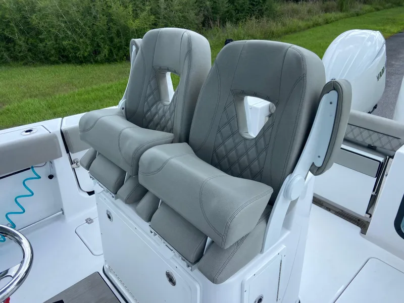 Slide: The Image of 2025 Sportsman Open 262 Center Console boat seats with gray upholstery and diamond stitching. - 18