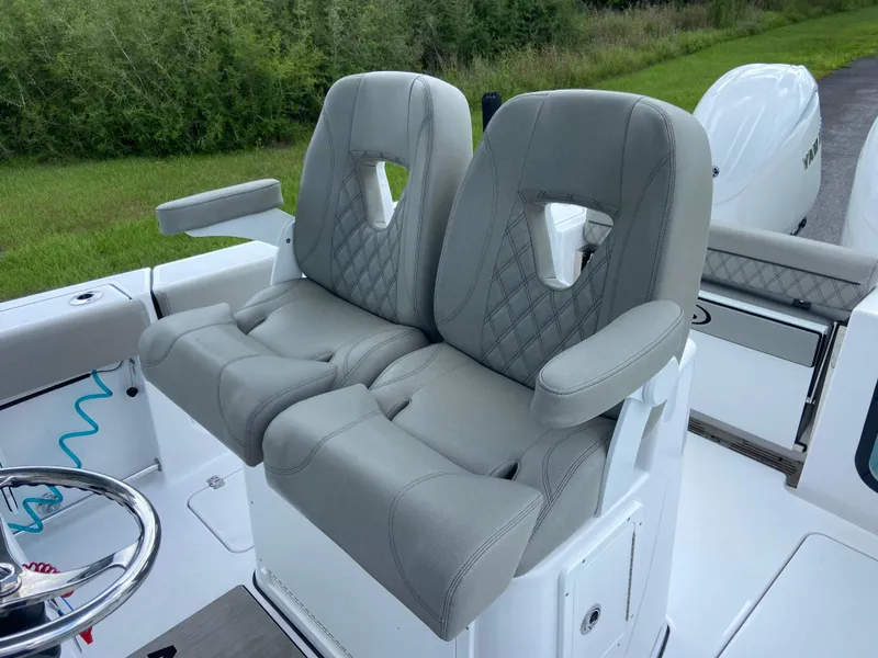 Slide: The Image of 2025 Sportsman Open 262 Center Console boat seats, gray upholstery, dual seating, outdoor setting. - 19
