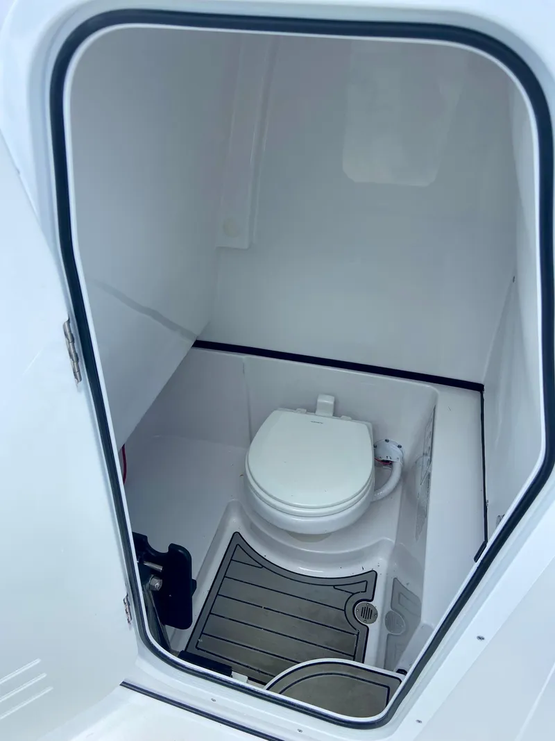 Slide: The Image of 2025 Sportsman Open 262 Center Console boat interior with compact marine toilet. - 5