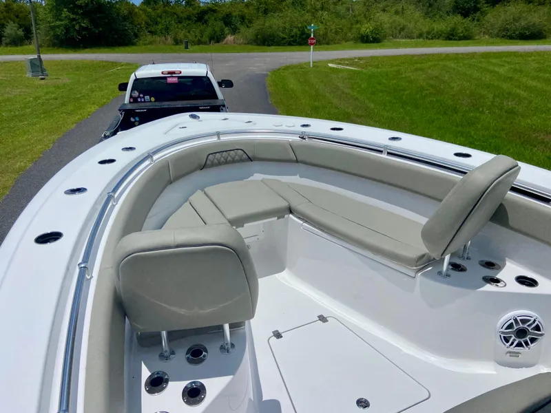 Slide: The Image of 2025 Sportsman Open 262 Center Console boat with seating, parked on a trailer near a grassy area. - 8