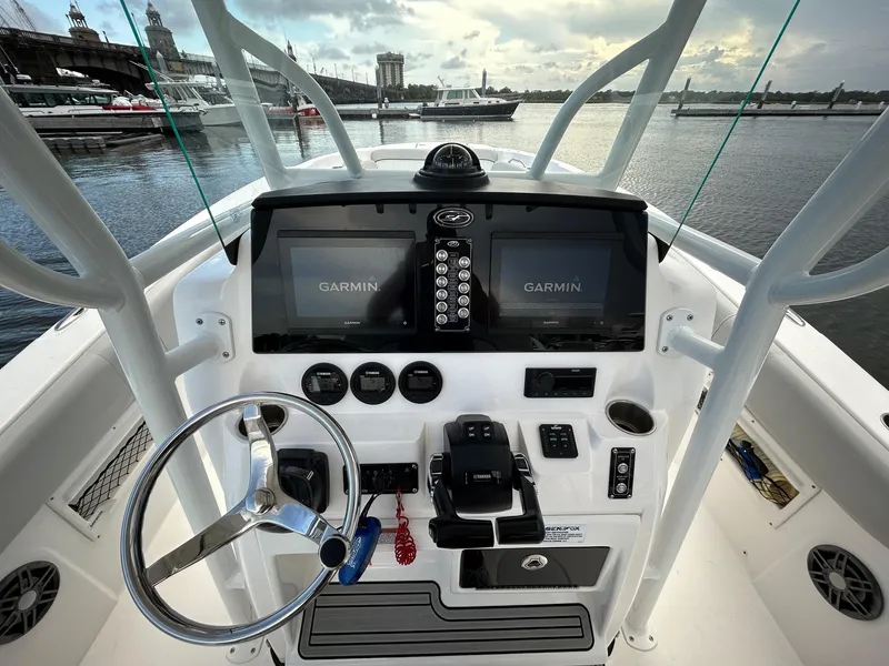 Slide: The Image of 2022 Sea Fox 268 Commander boat dashboard with Garmin displays, steering wheel, and controls. - 2