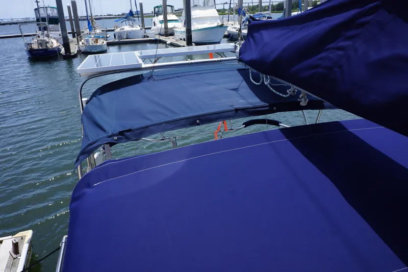 Slide: The Image of Sailboat with blue canvas cover docked at marina, Hunter 35.5, 1993 model. - 10