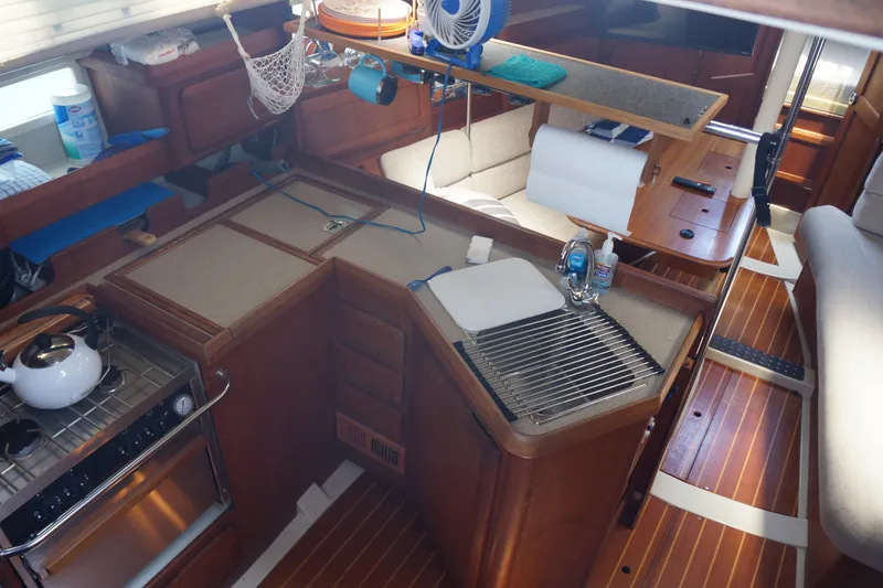 Slide: The Image of Cozy kitchen area in a 1993 Hunter 35.5 sailboat with wooden cabinetry and appliances. - 26