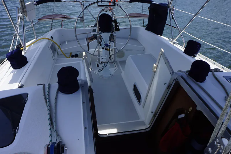Slide: The Image of Cockpit of 1993 Hunter 35.5 sailboat with steering wheel and seating, on calm water. - 6