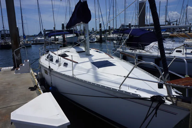 Slide: The Image of 1993 Hunter 35.5 sailboat docked at marina, surrounded by other boats. - 7