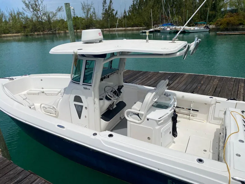 Slide: The Image of 2006 Everglades 260 CC boat docked in a serene marina setting. - 0