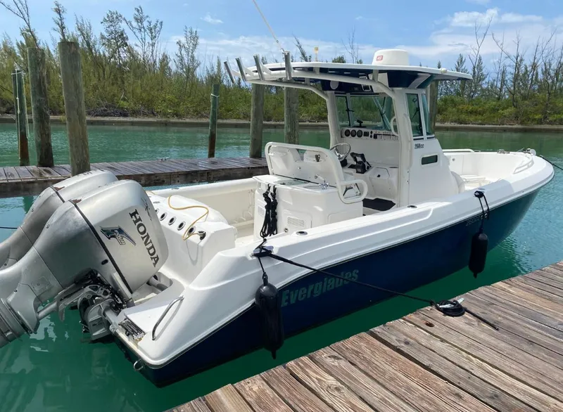 Slide: The Image of 2006 Everglades 260 CC boat docked, featuring Honda outboard motor, in a serene marina setting. - 1