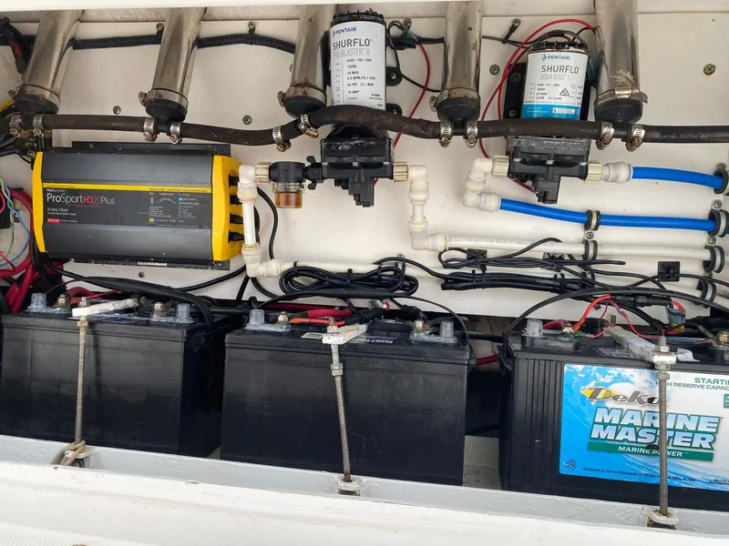 Slide: The Image of Electrical and plumbing system of a 2006 Everglades 260 CC boat, featuring batteries and pumps. - 12