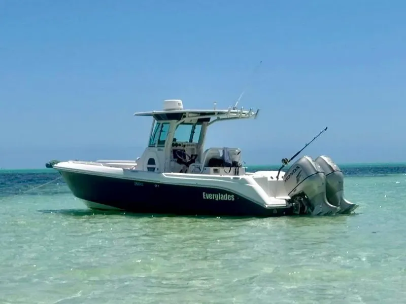 Slide: The Image of 2006 Everglades 260 CC boat anchored in clear, shallow water under a bright blue sky. - 2