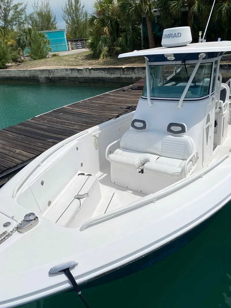 Slide: The Image of 2006 Everglades 260 CC boat docked by a serene waterfront. - 3