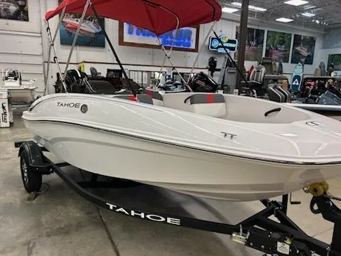 Slide: The Image of 2025 Tahoe T16 boat with red canopy in showroom, displayed on trailer. - 2