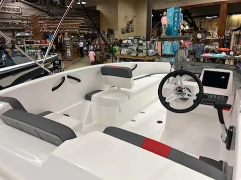 Slide: The Image of 2025 Tahoe T16 boat interior with modern steering and seating, displayed in a showroom. - 4