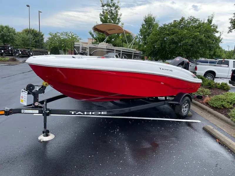 Slide: The Image of 2025 Tahoe T18 boat in vibrant red on a trailer, parked outdoors. - 2