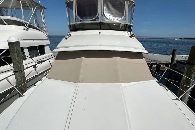 Slide: The Image of 1988 Carver 38 Aft Cabin yacht docked by the sea under clear blue skies. - 15